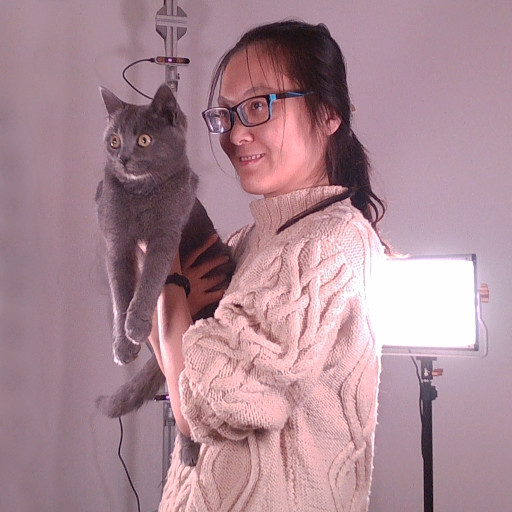 A woman holding a cat and being recorded by a volumetric video system